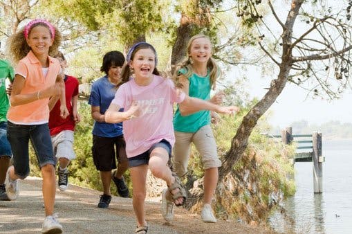 Group of children running outdoors near water