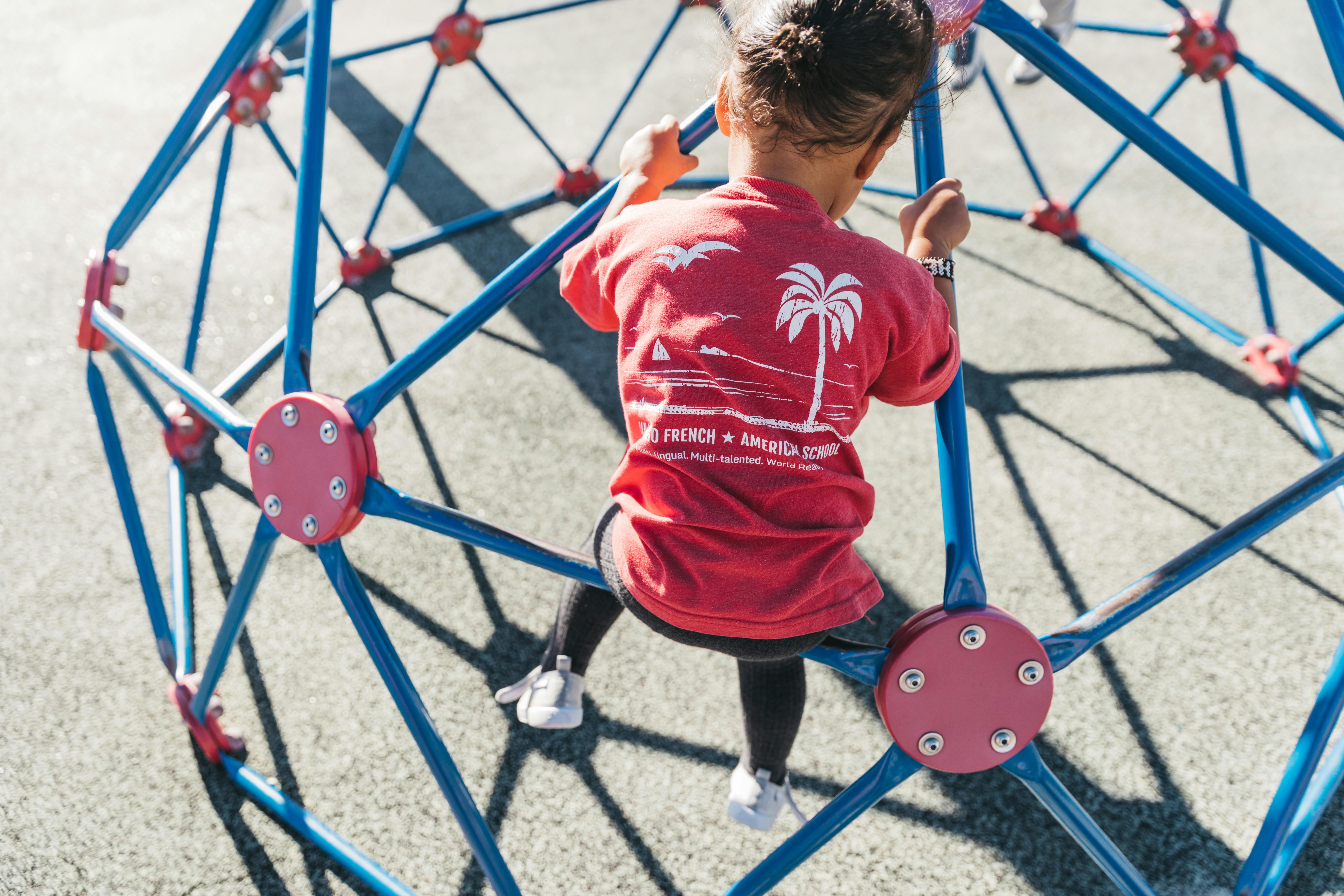 Child climbing on a blue geometric dome climber