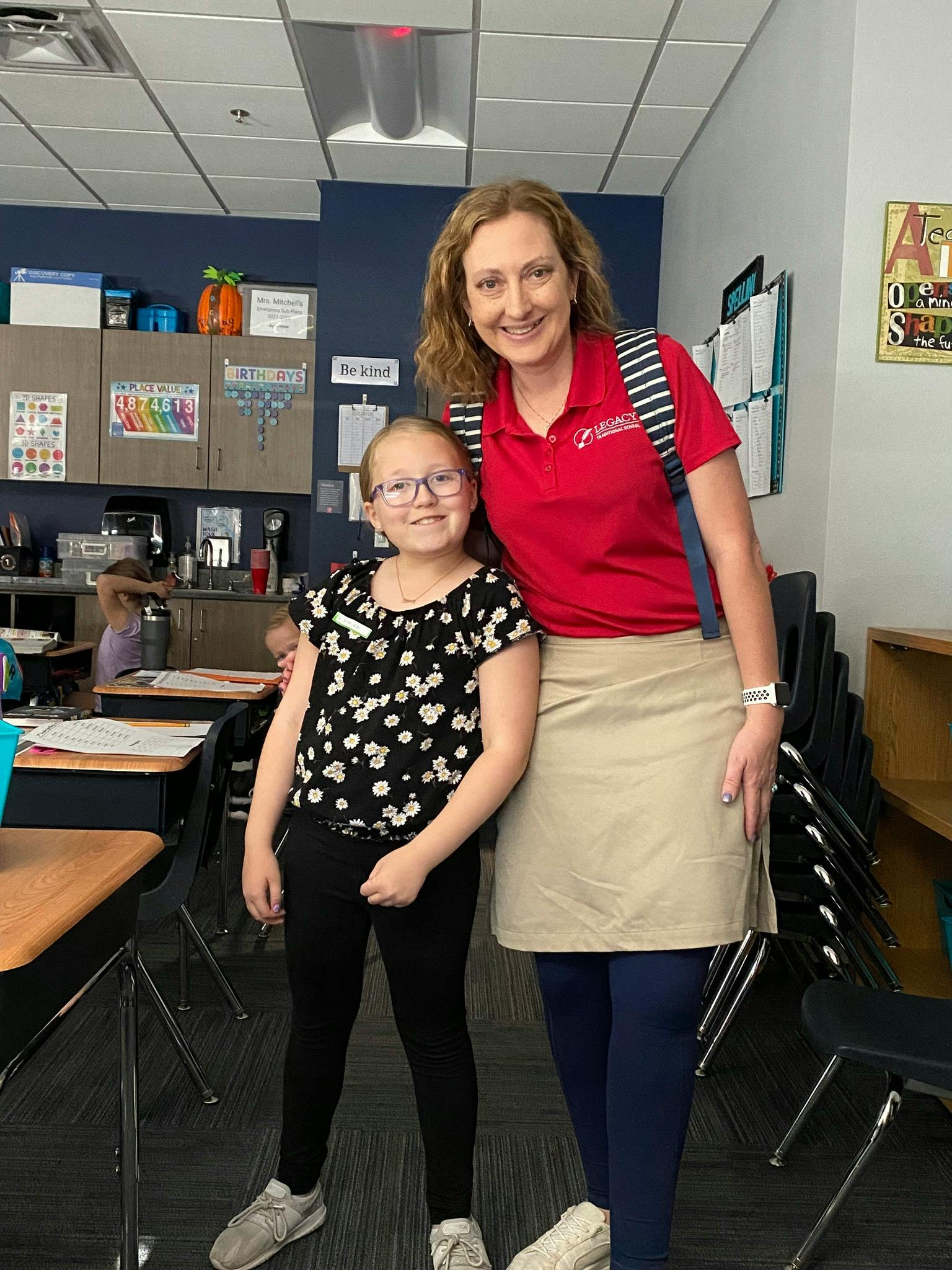 Adult and child standing in a classroom