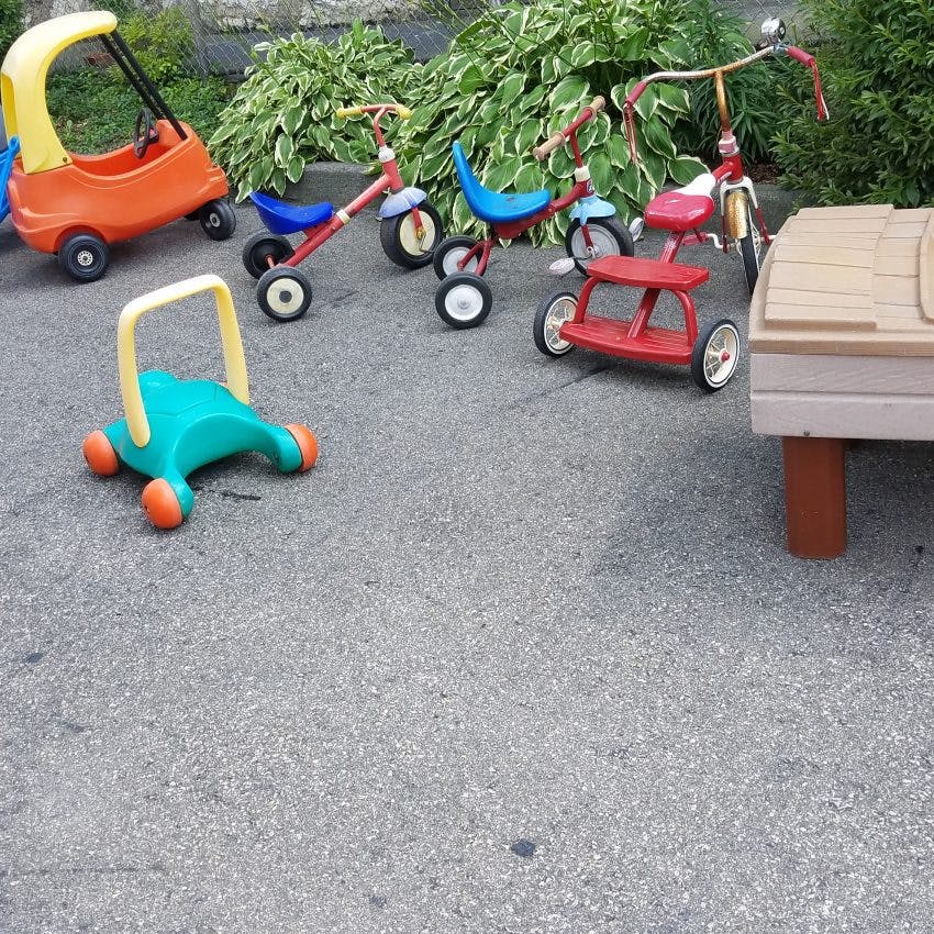 Children's ride-on toys and tricycles on pavement