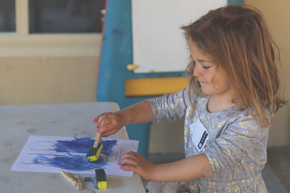 Child painting with a sponge brush on paper