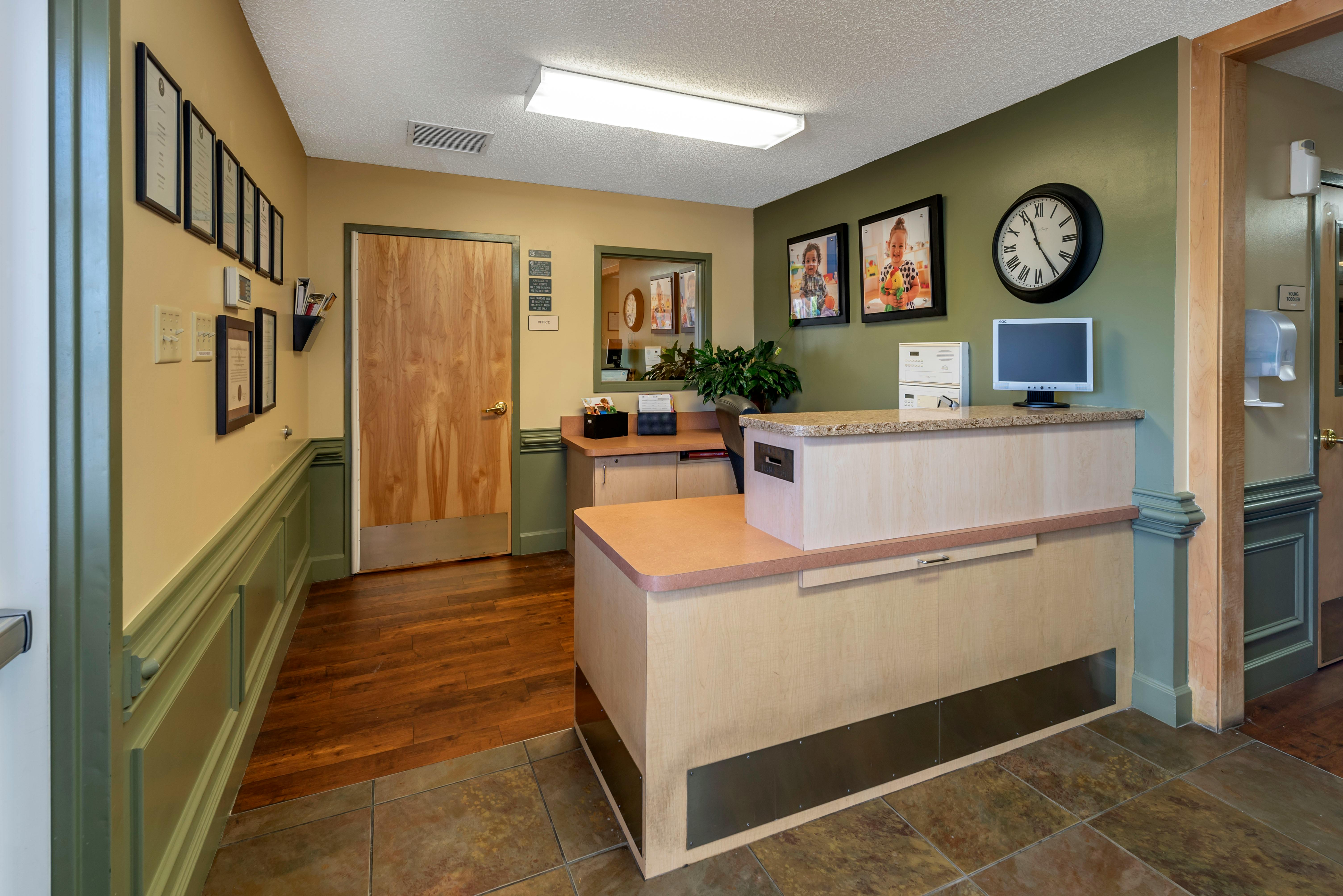 Reception desk with computer and large clock on the wall