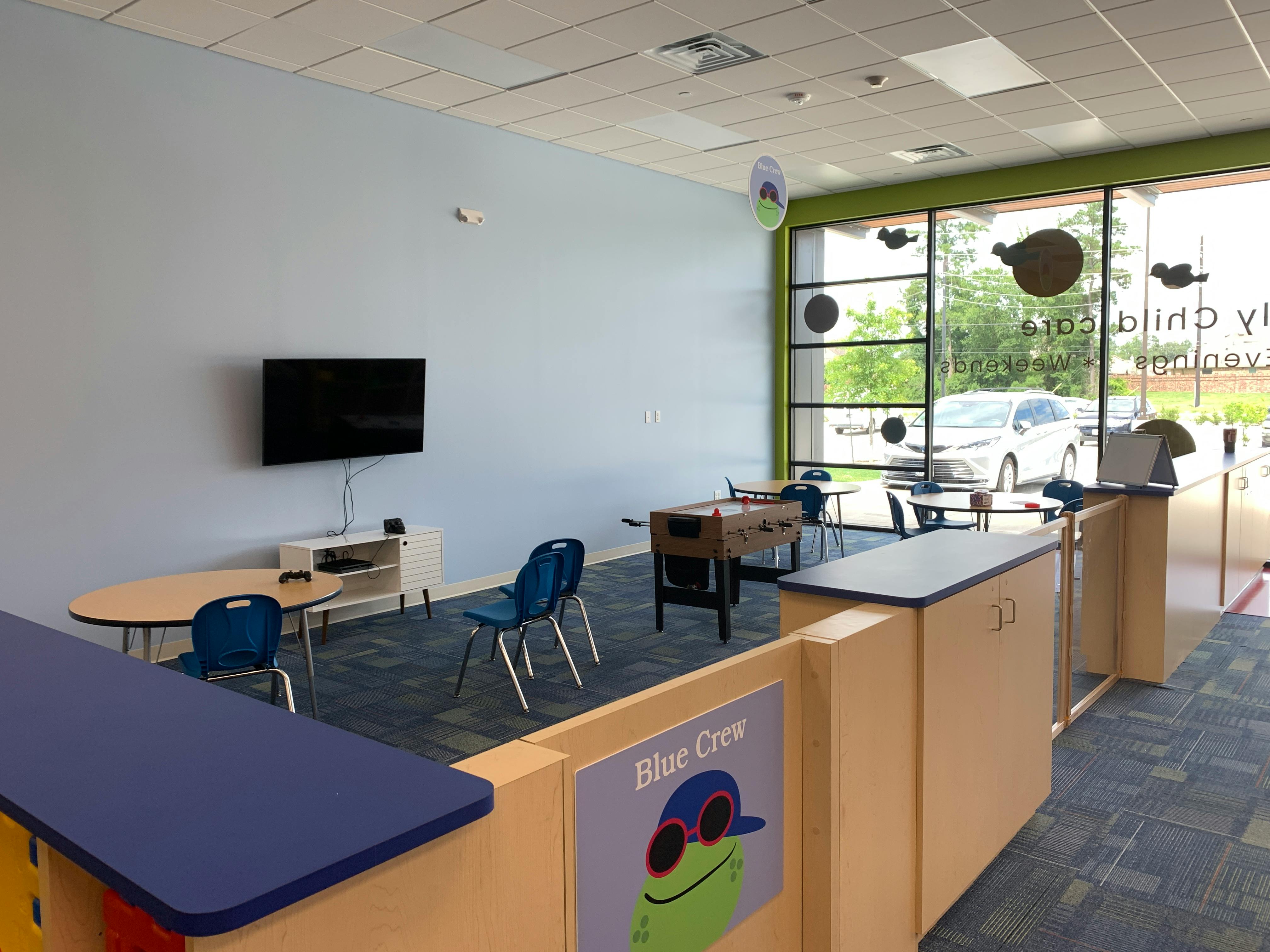 Children's play area with TV, tables, chairs, and foosball table