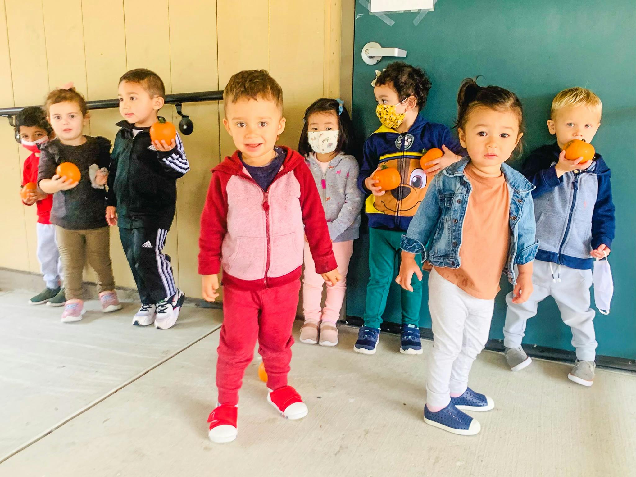 Group of children holding oranges