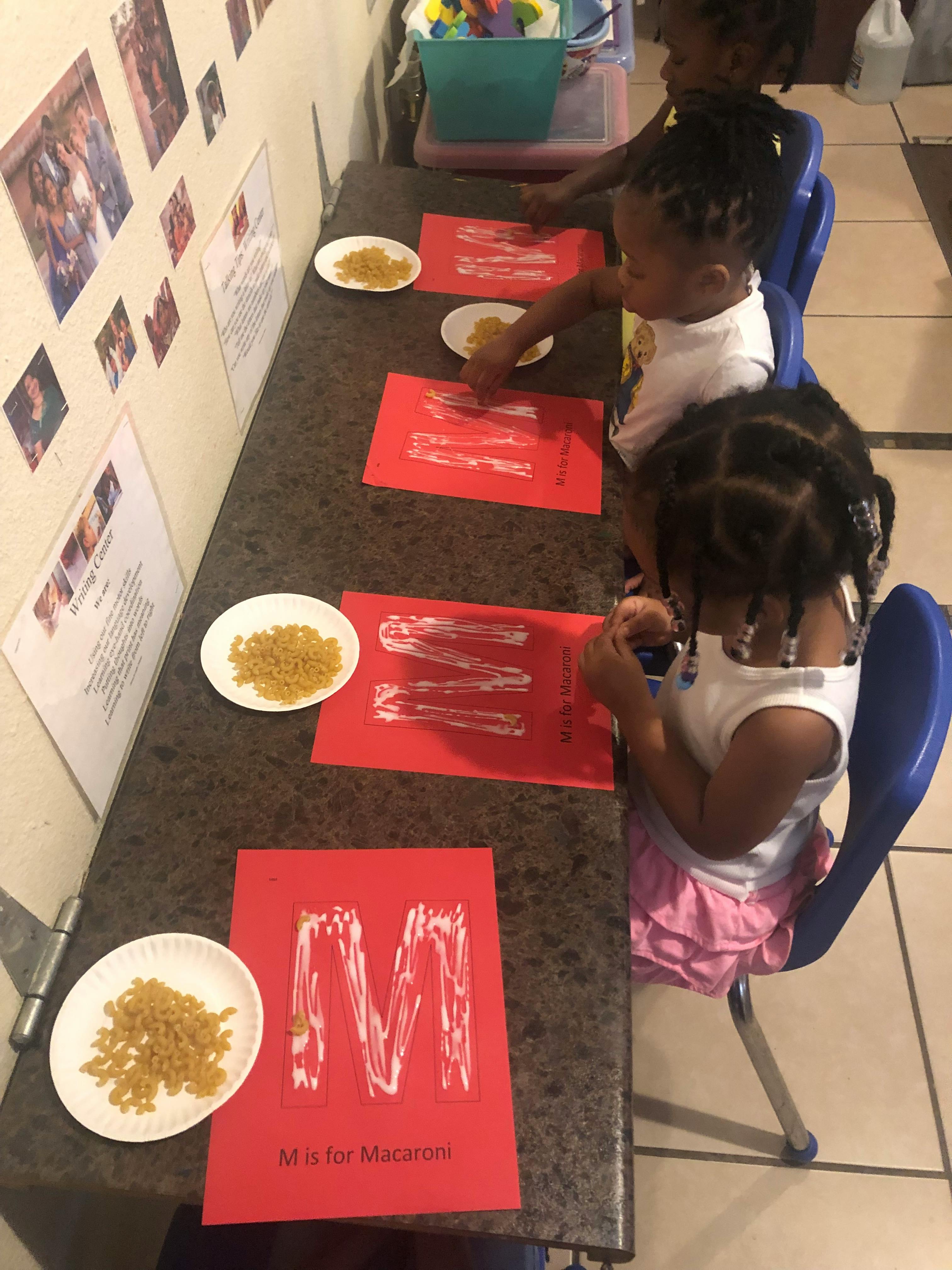 Children doing an art activity with pasta and red paper