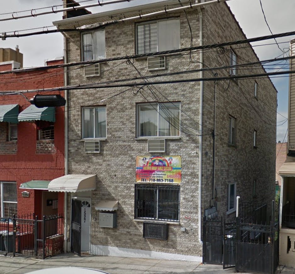 Three-story brick building with windows and a colorful sign on the front