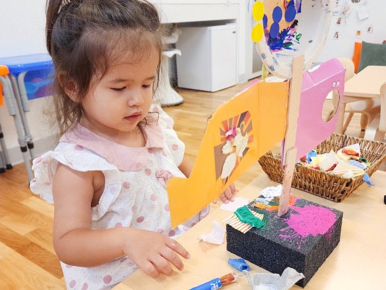 Child looking at a craft project on a table