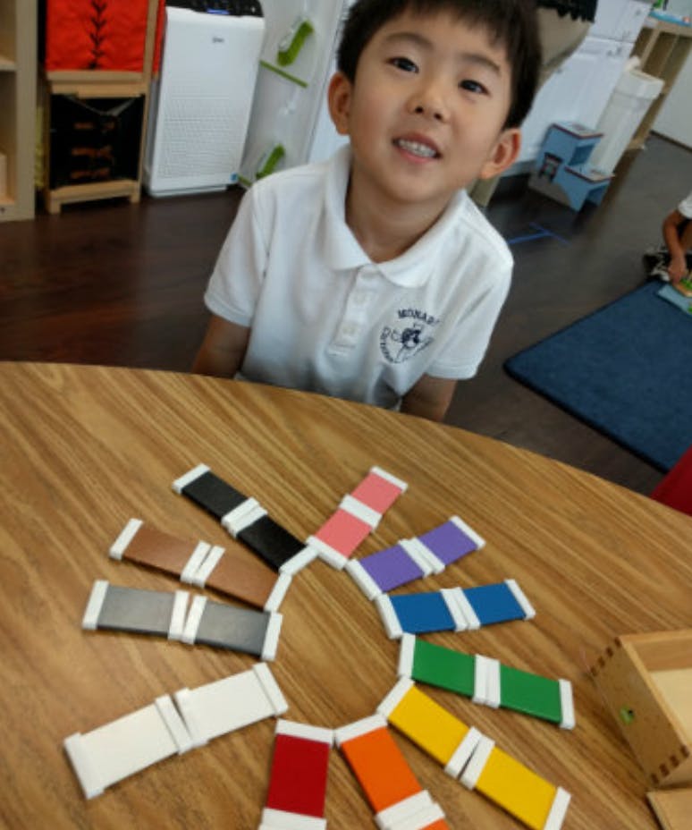 Child at a table with colorful blocks arranged in a circle