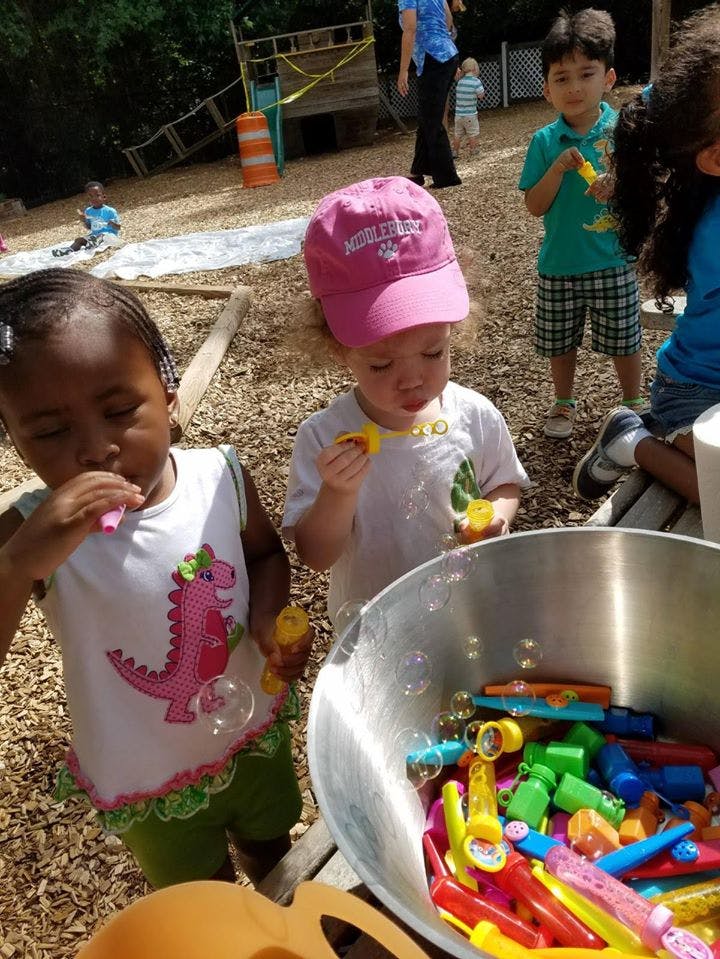 Two children blowing bubbles outdoors