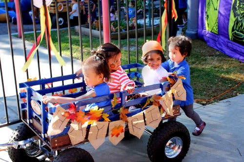 Children playing in and around a decorated wagon