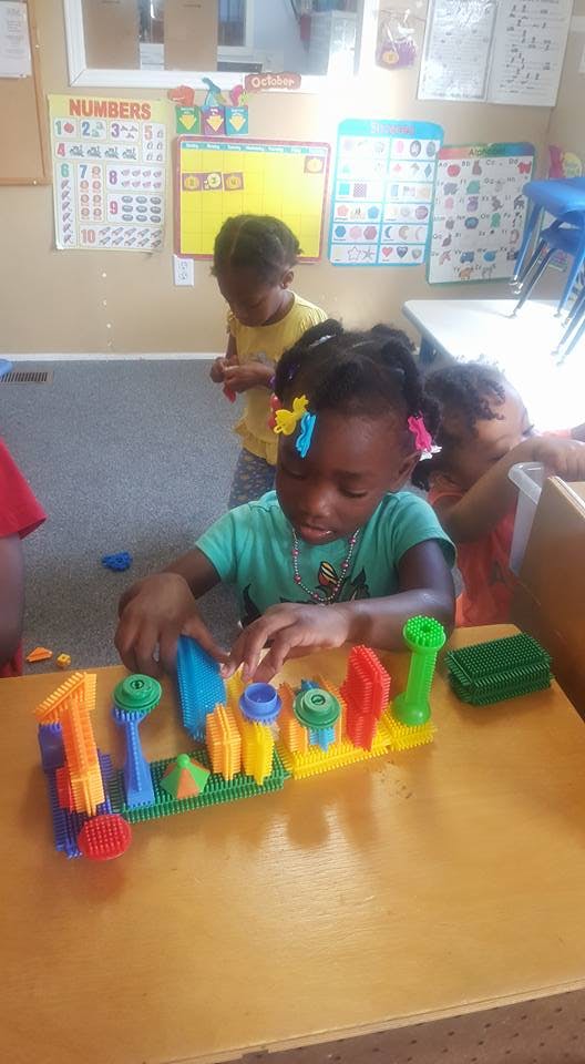 Child playing with colorful building blocks at a table