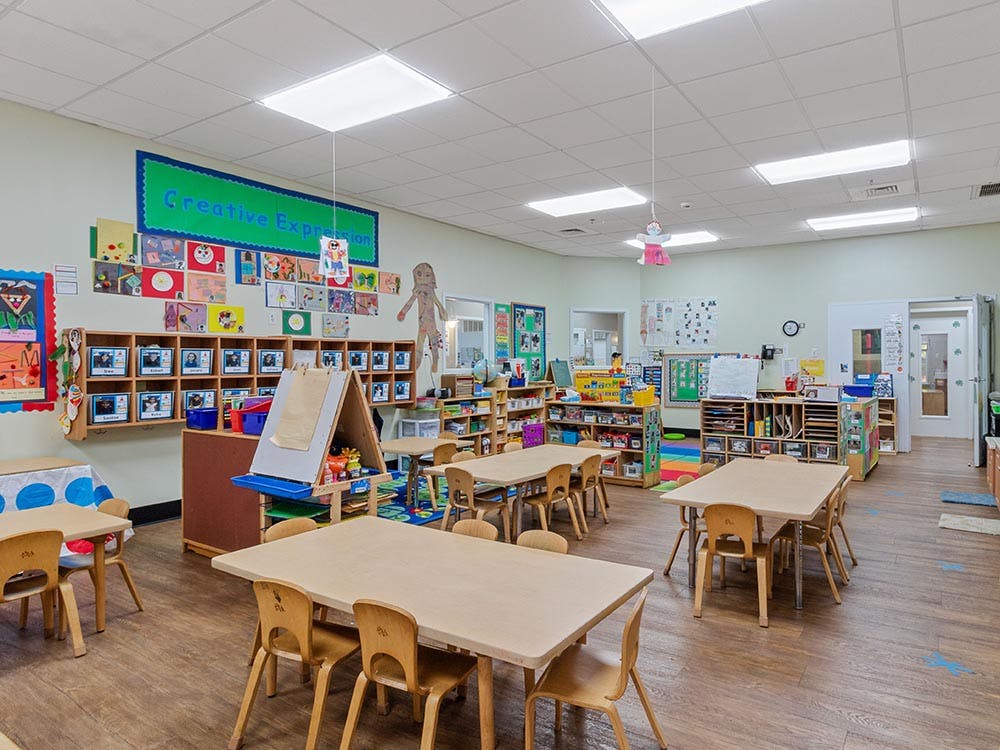 A colorful classroom with small tables and chairs for children