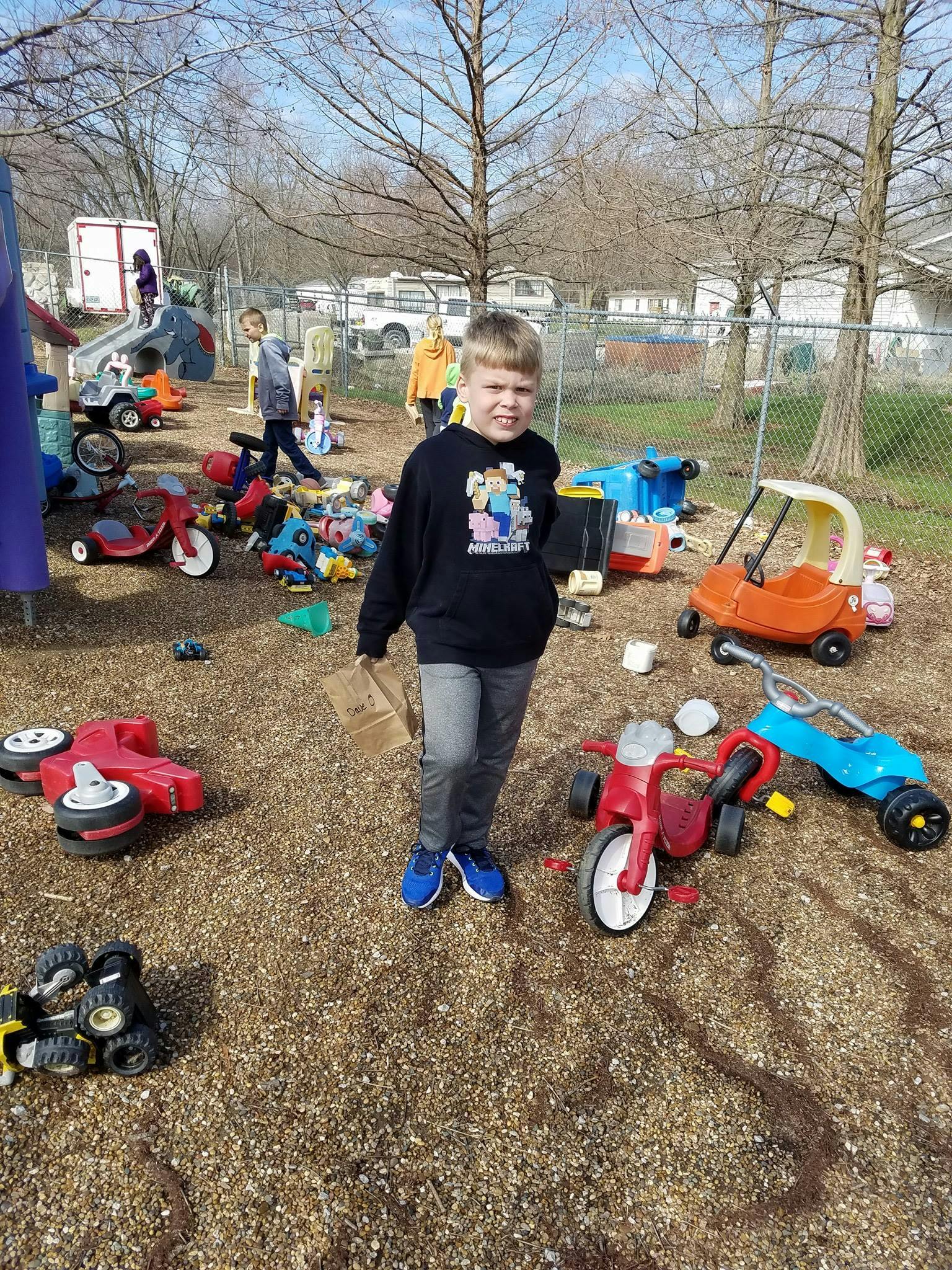 Child standing in a playground with toys