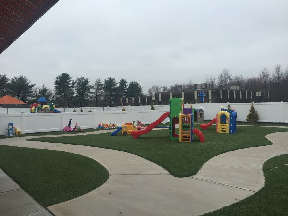 Outdoor playground with colorful slides and play structures on artificial turf