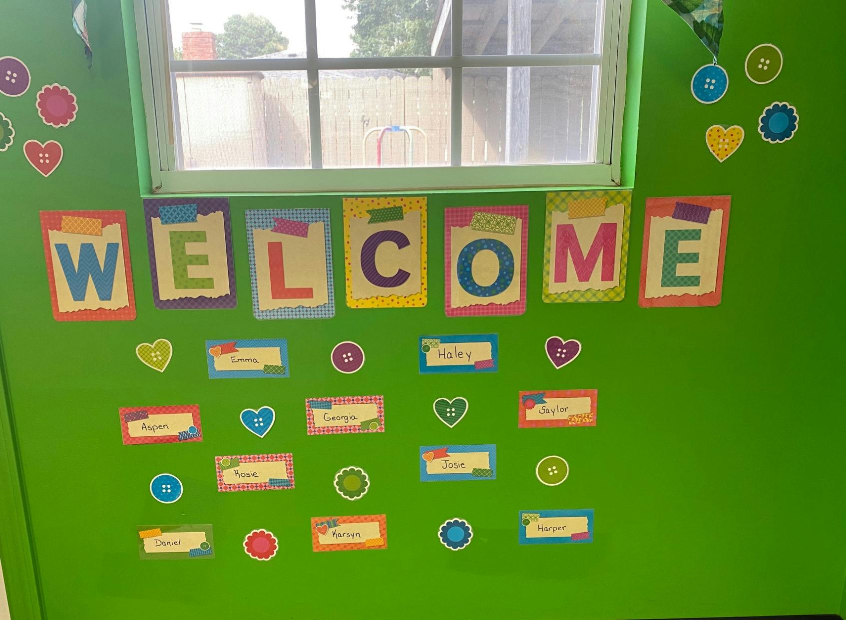 Green wall with "WELCOME" sign and decorative cutouts