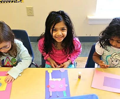 Three children at a table doing crafts