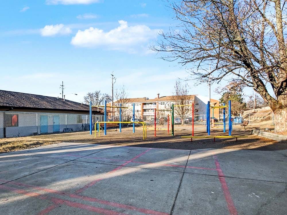 Empty playground with colorful monkey bars and building in the background