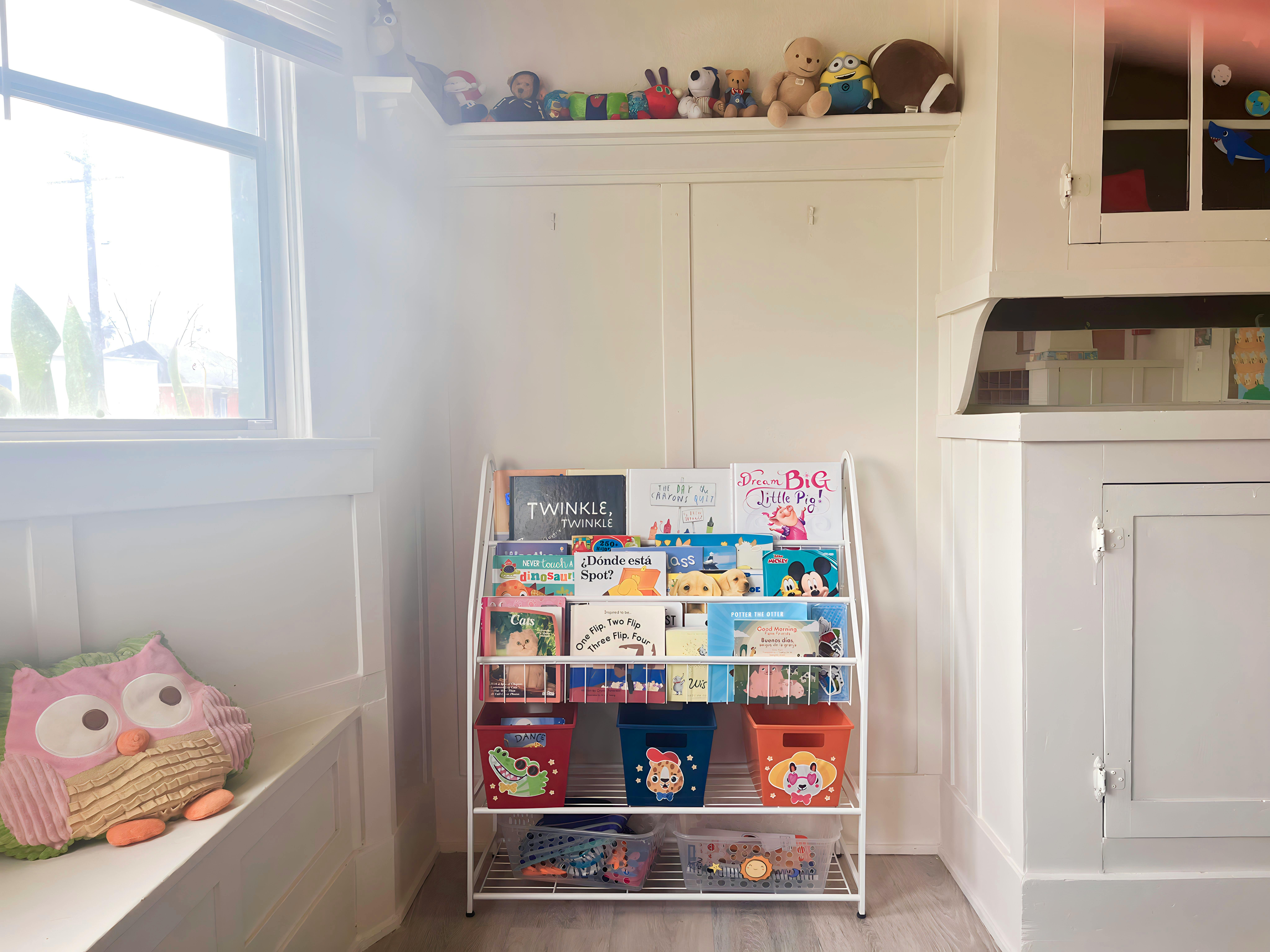 White bookshelf with children's books and toy bins