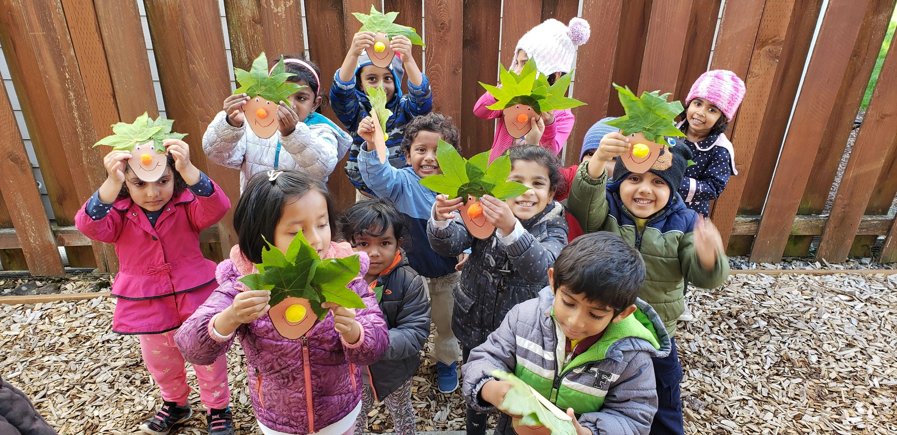 Group of children holding up leaf crafts