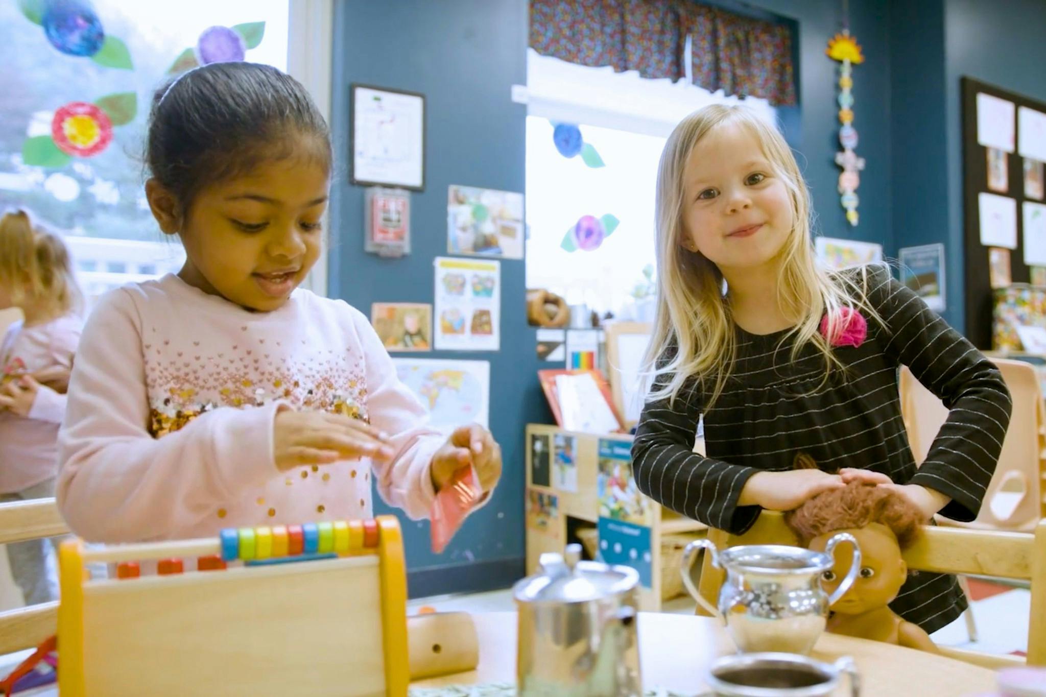 Two children playing with toys in a classroom
