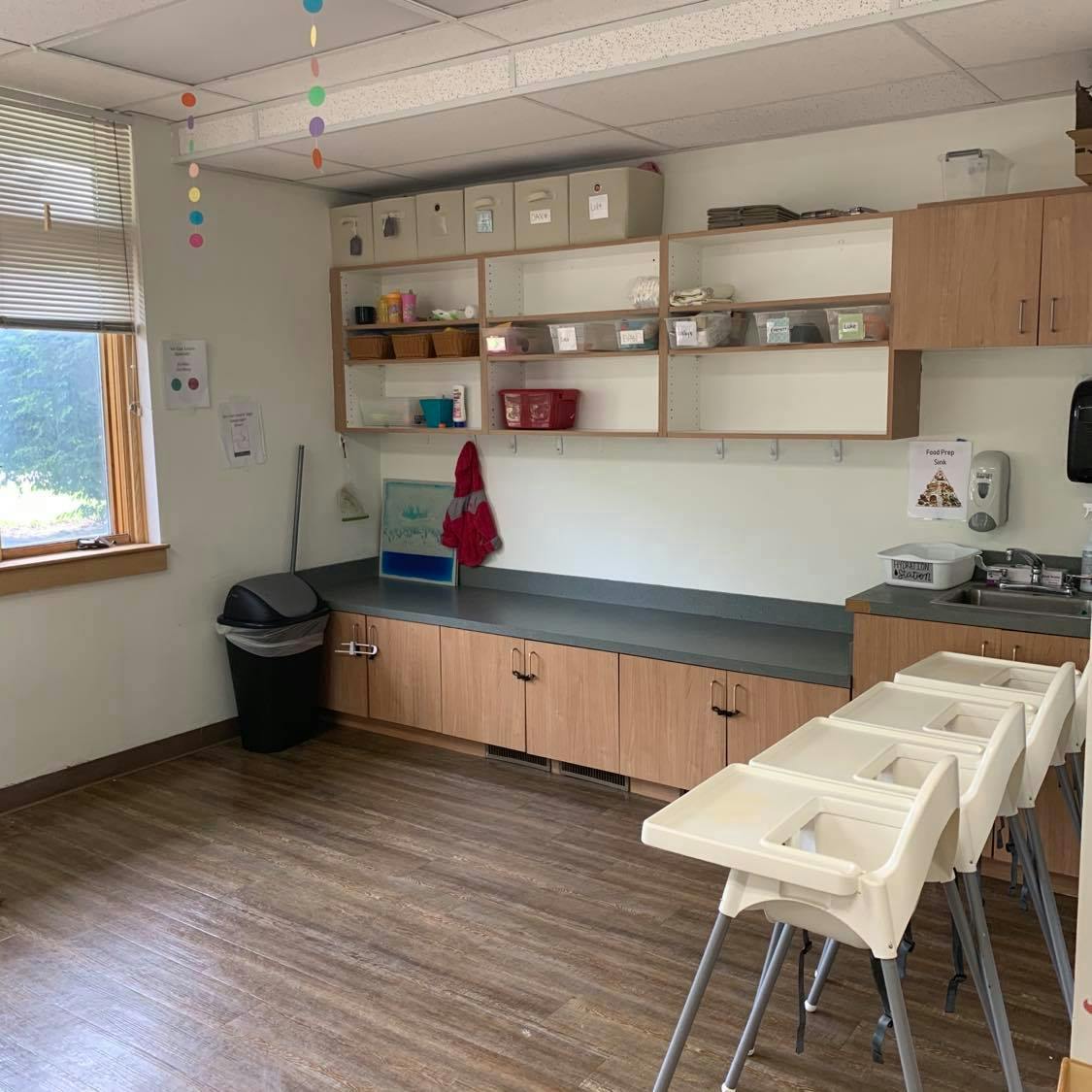Classroom with shelves, cabinets, and high chairs