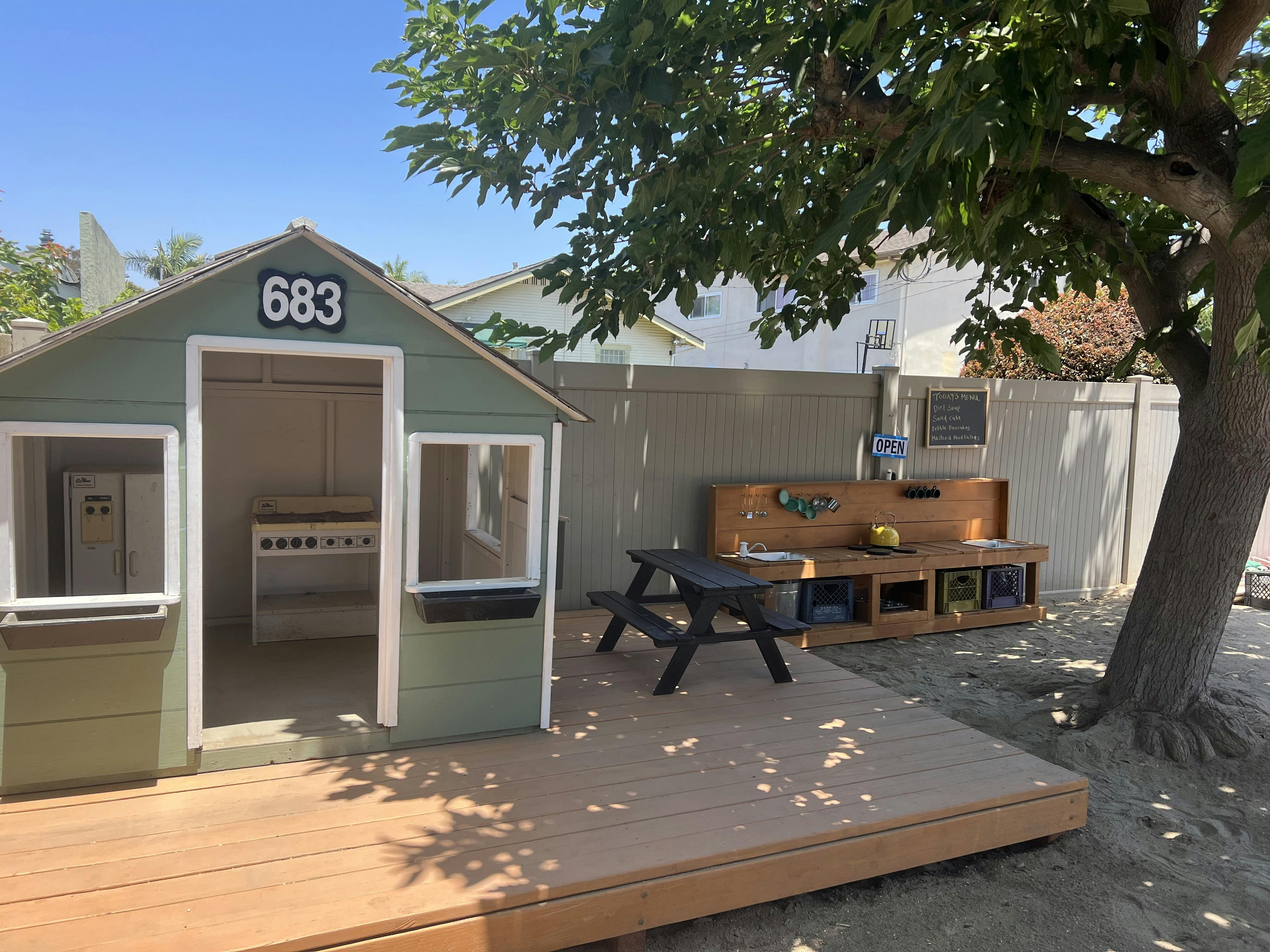 Playhouse with a small picnic table and outdoor play kitchen