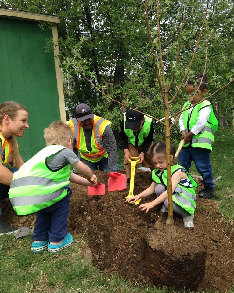 Adults and children planting a tree