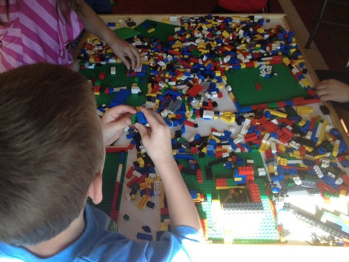 Child playing with colorful building blocks on a table