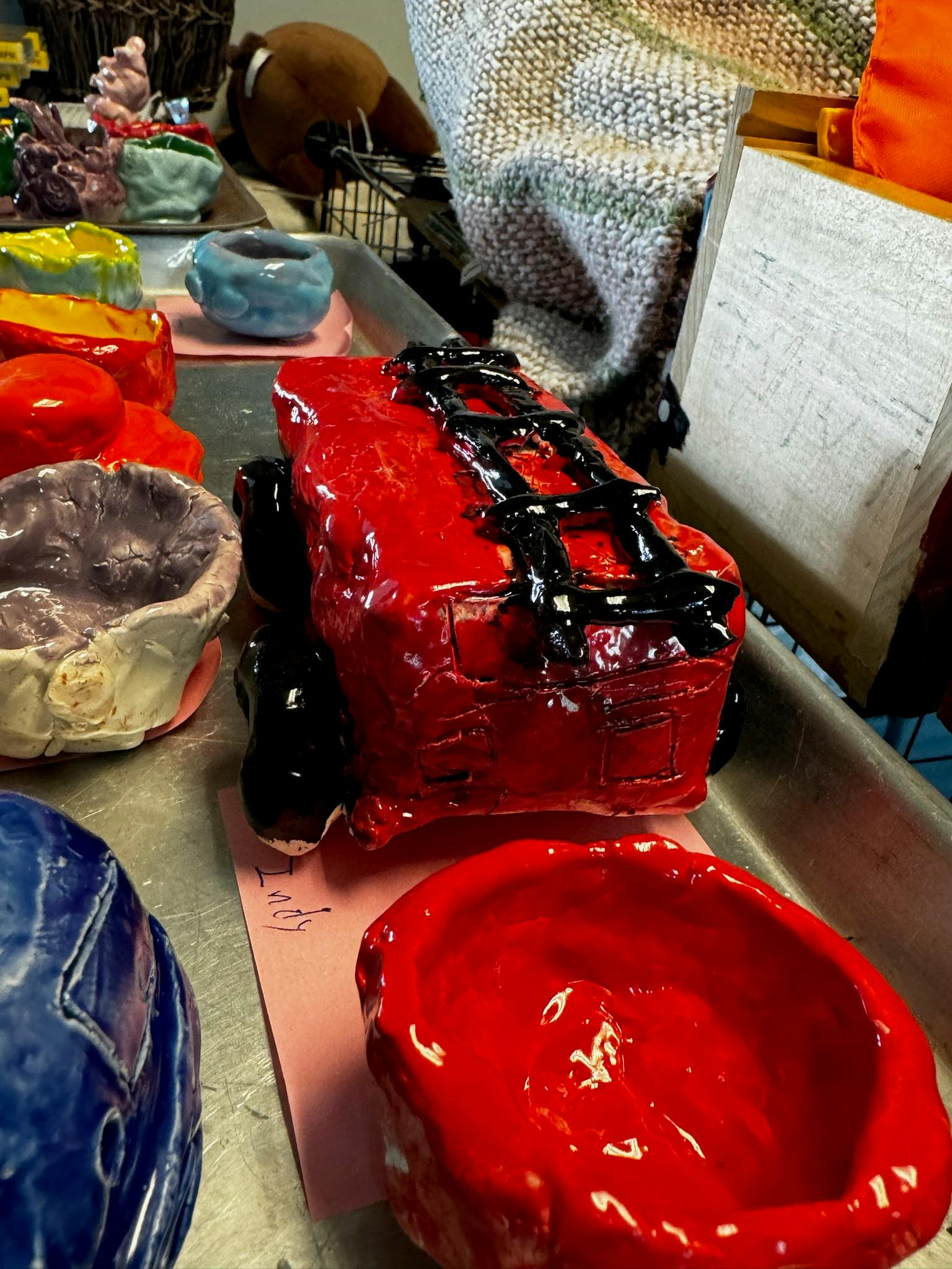 Red ceramic truck and other ceramic pieces on a metal tray