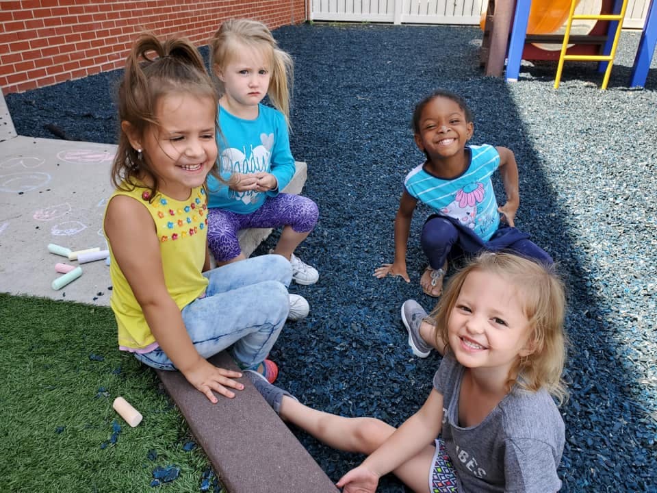 Four children sitting on a playground