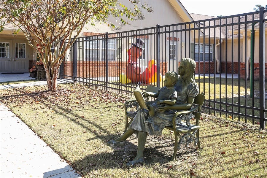 Statue of a person reading to a child on a bench