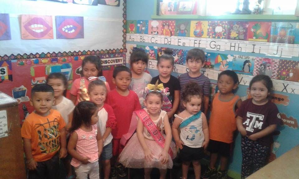 Group of children standing in a classroom