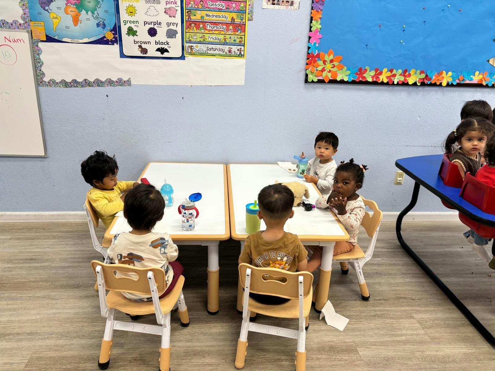 Children sitting around tables in a classroom