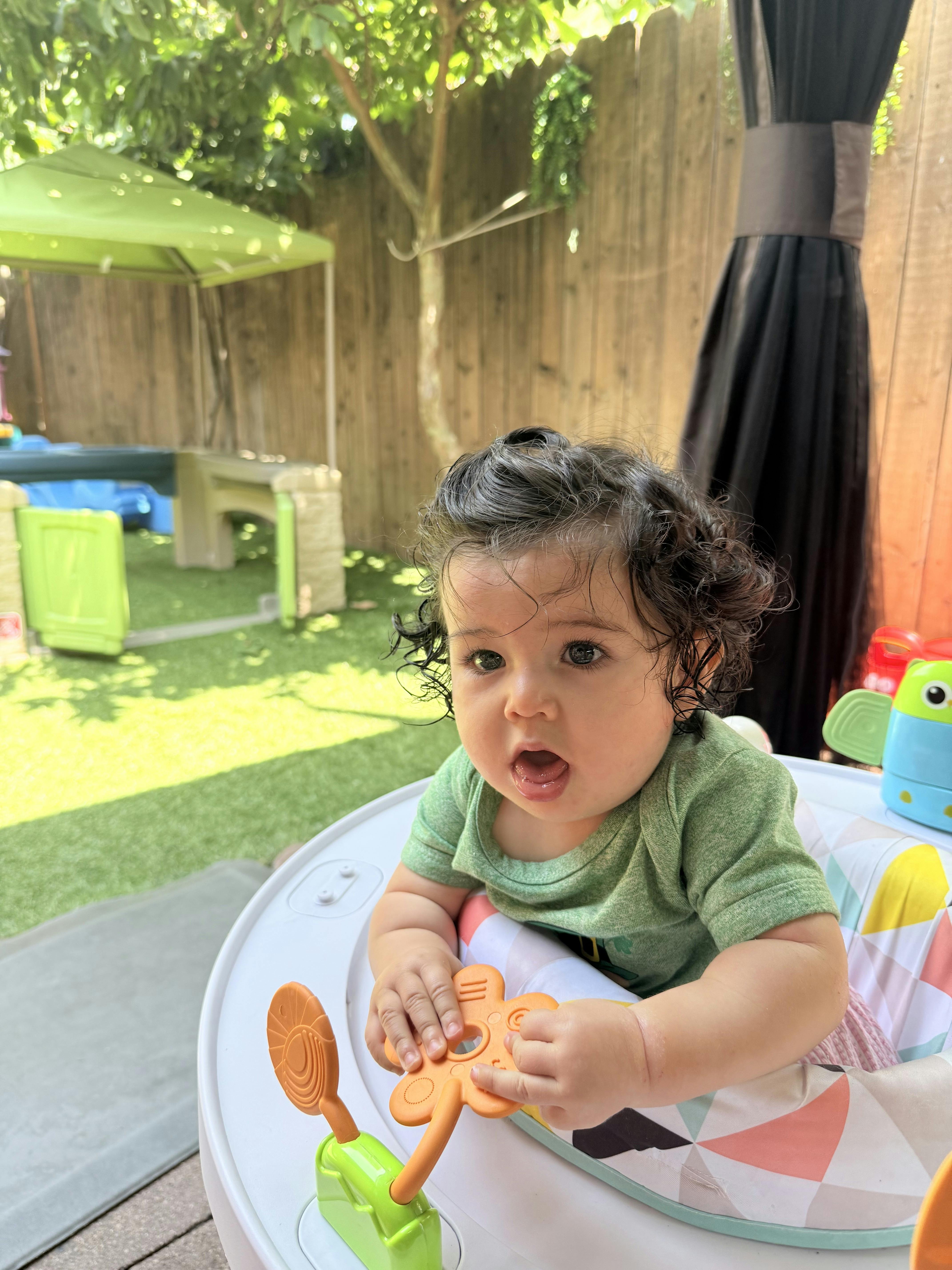 Child in a baby walker playing with a toy