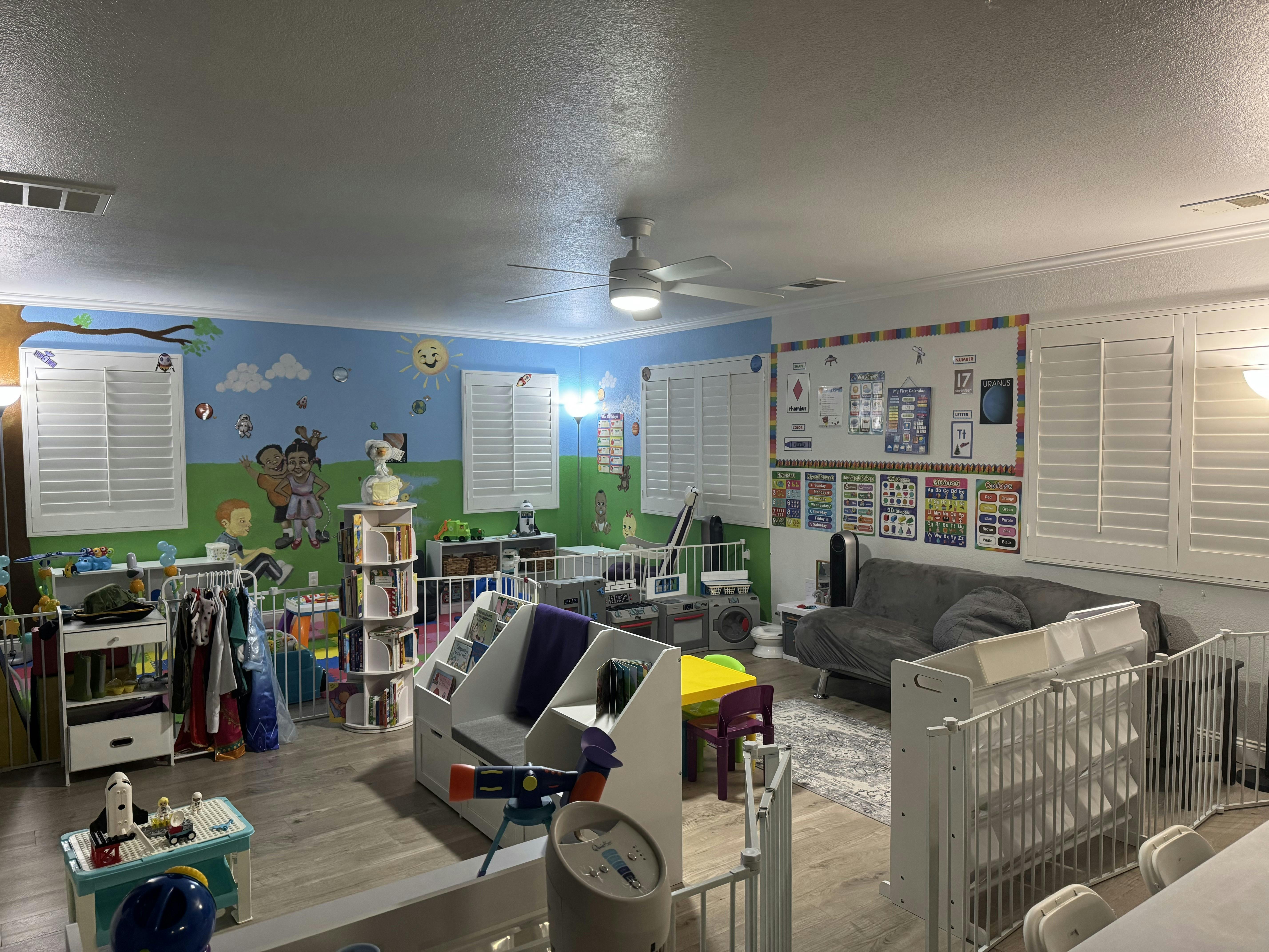 Children's playroom with mural of a tree, sun, and people on walls