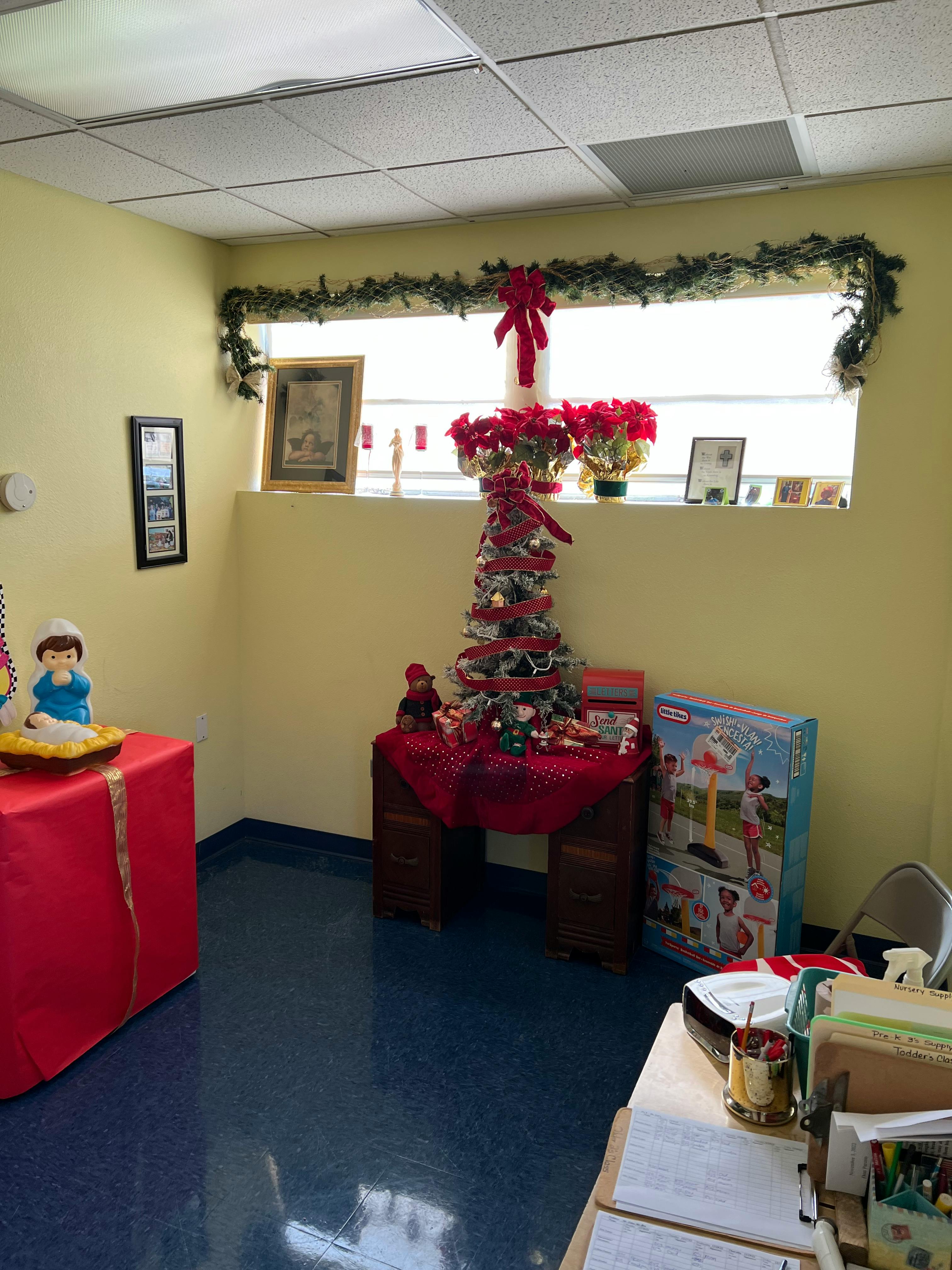 Room decorated with Christmas garland, a small Christmas tree, and poinsettias
