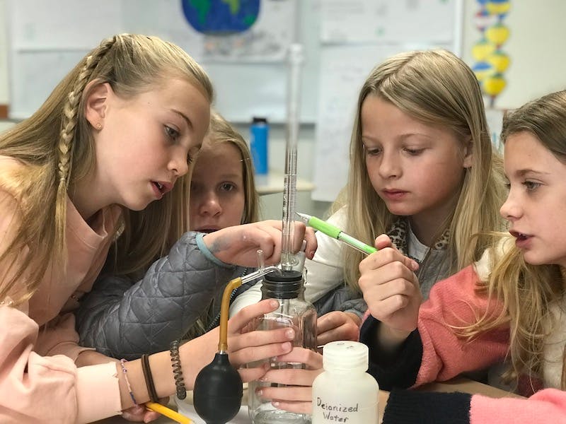 Children conducting a science experiment with laboratory equipment