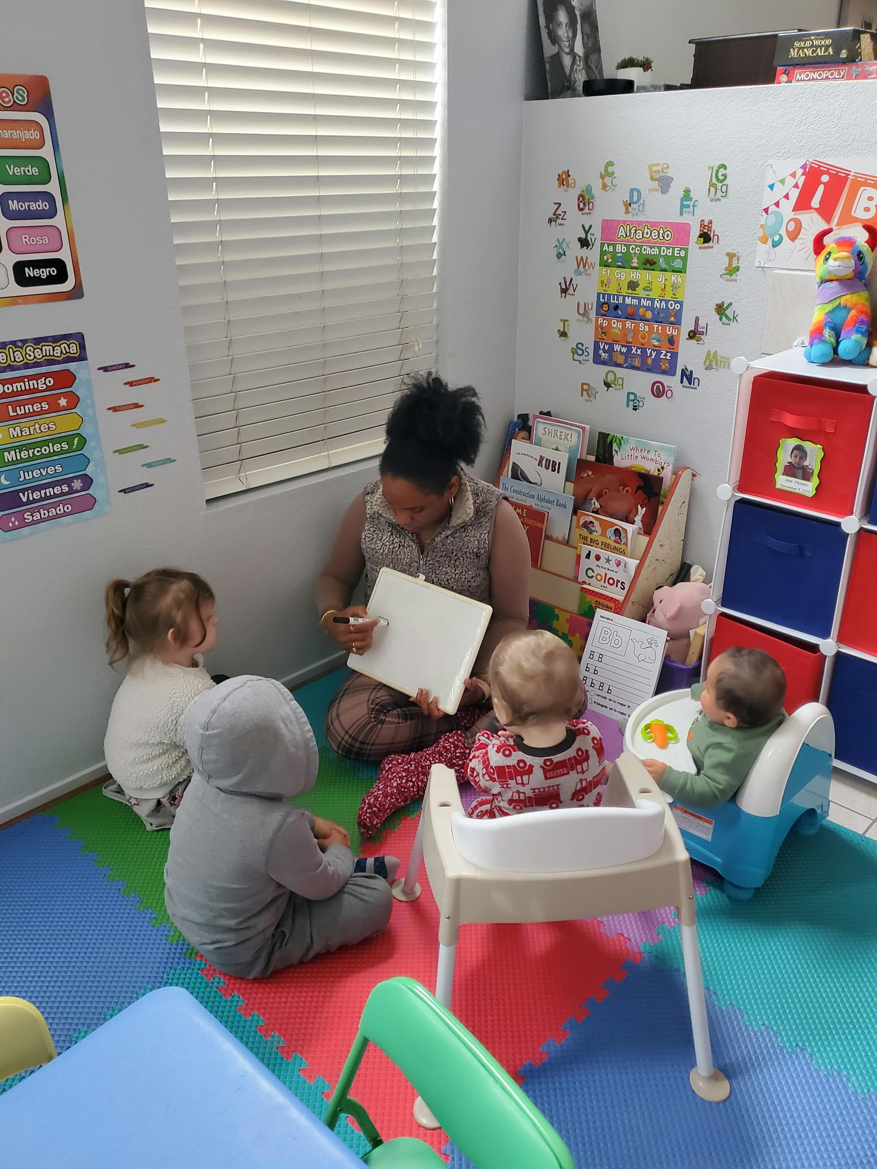 Person reading to three children in a room