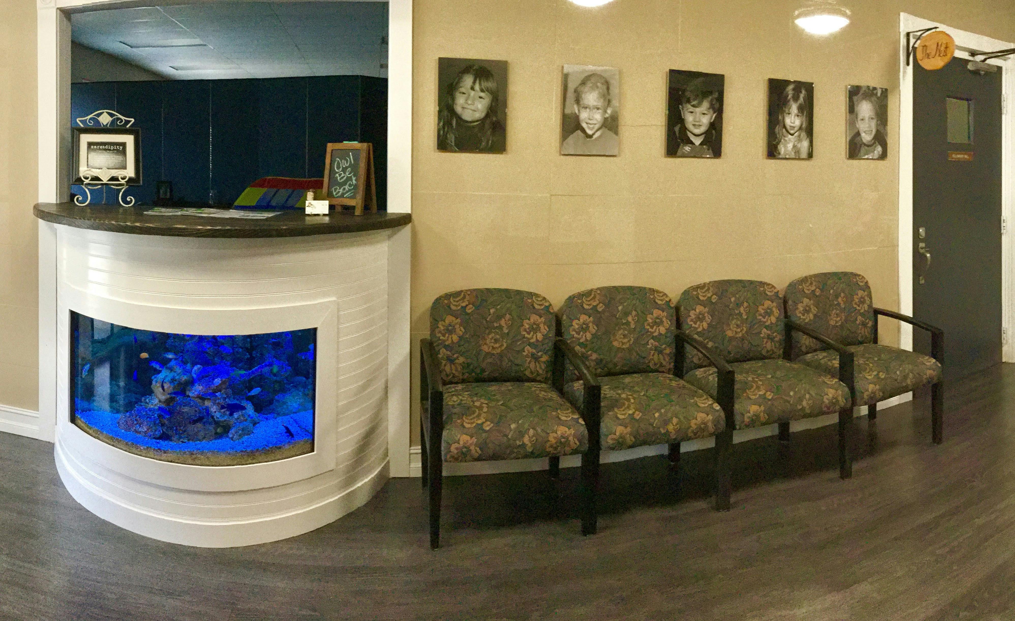 Reception desk with built-in aquarium and row of waiting room chairs