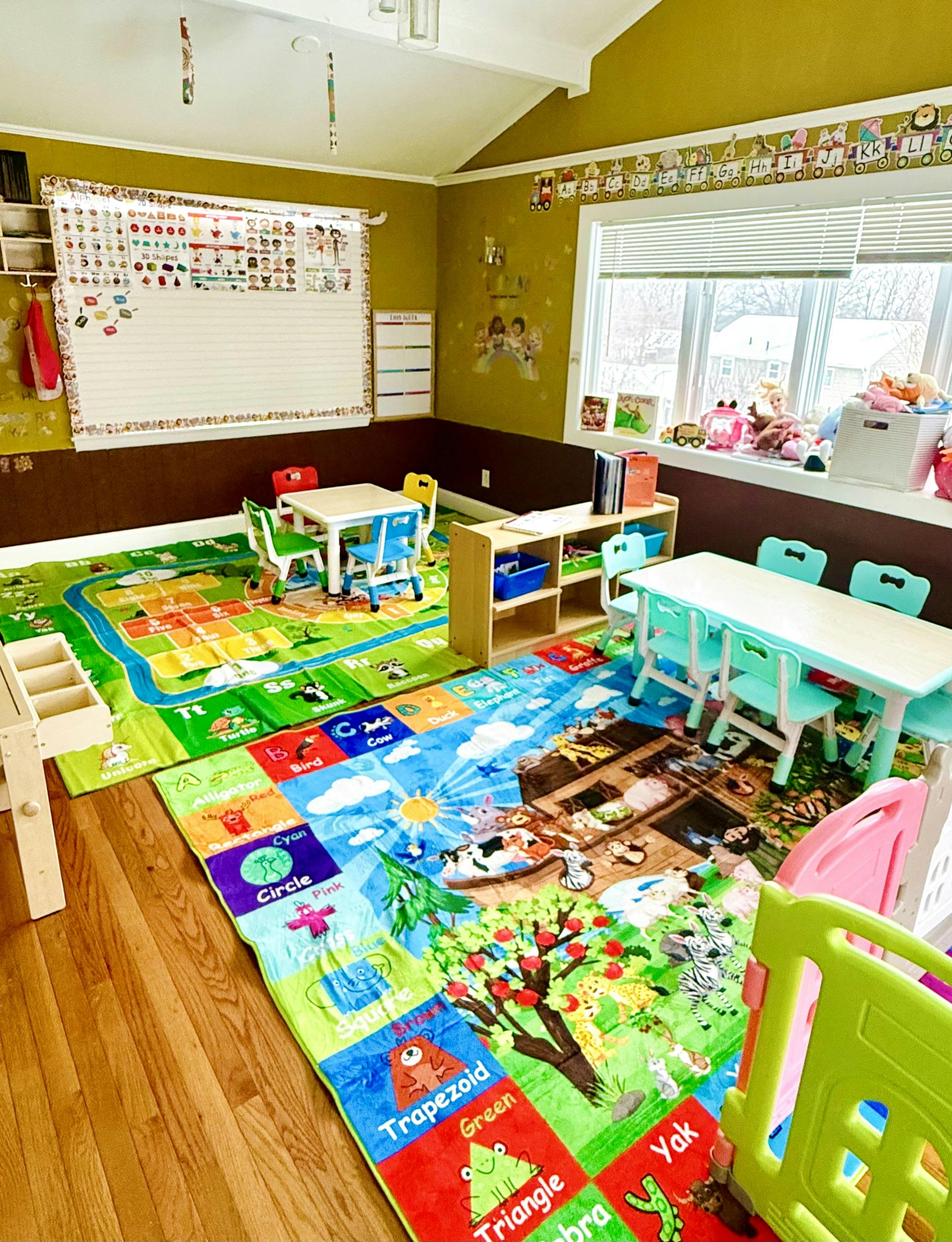 Classroom with colorful playmats, small tables and chairs, and teaching charts