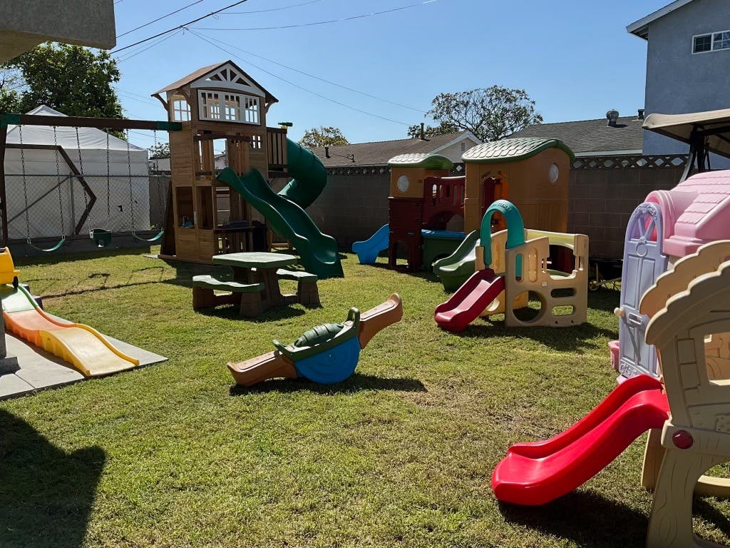 Outdoor playground with multiple slides, playhouses, and a picnic table