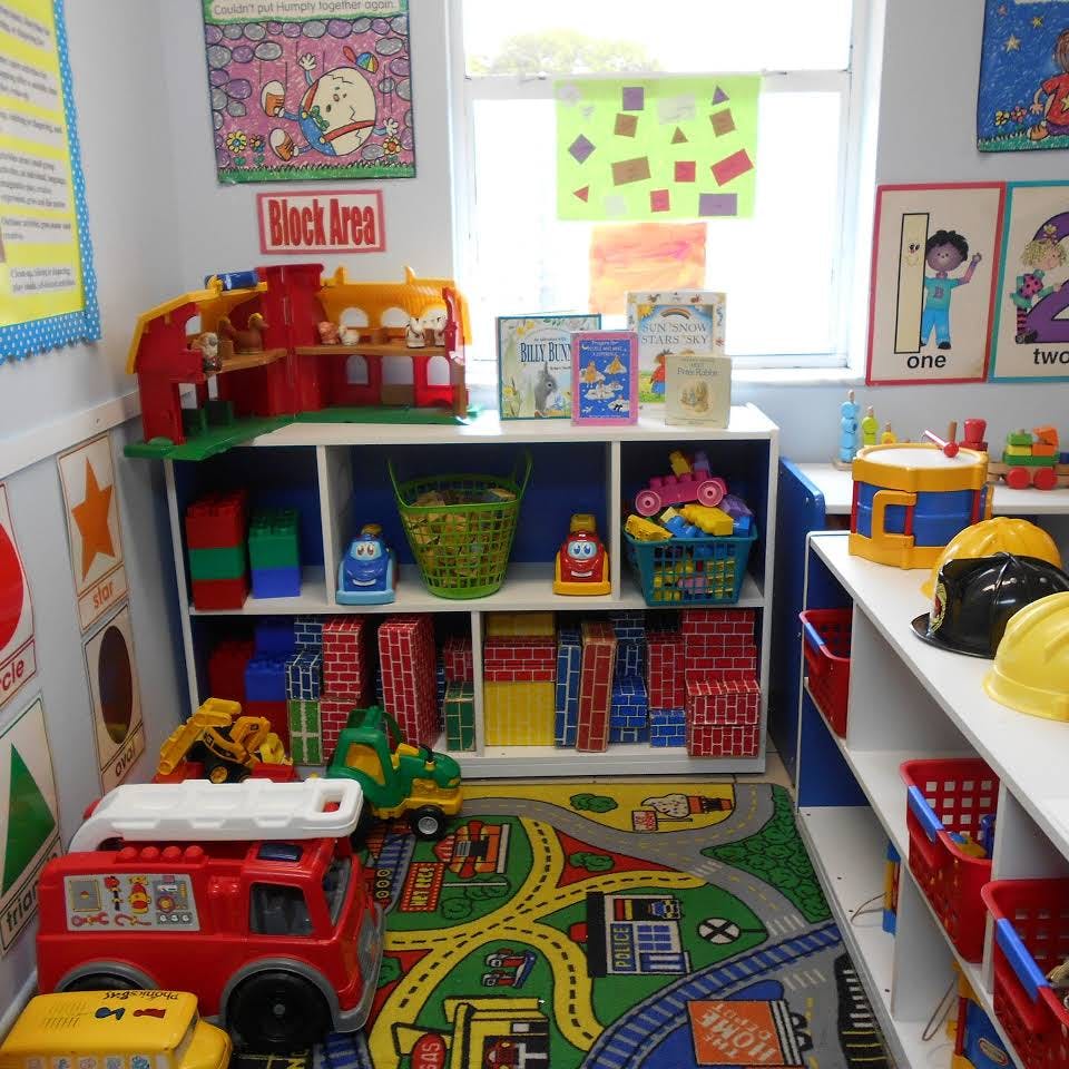 Playroom with shelves of toys, blocks, and a road map rug