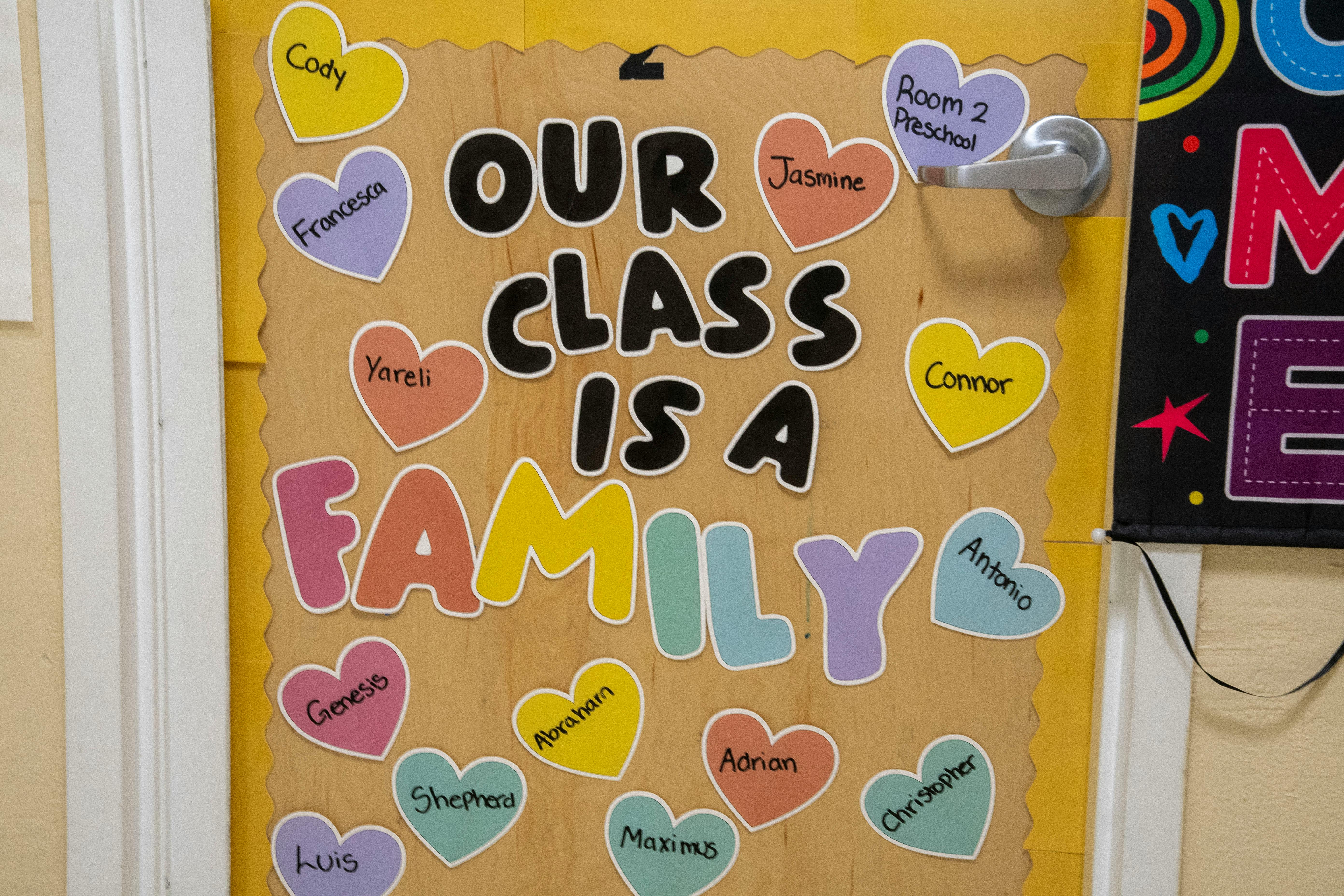 Door decoration with "Our Class Is A Family" and heart cutouts with names