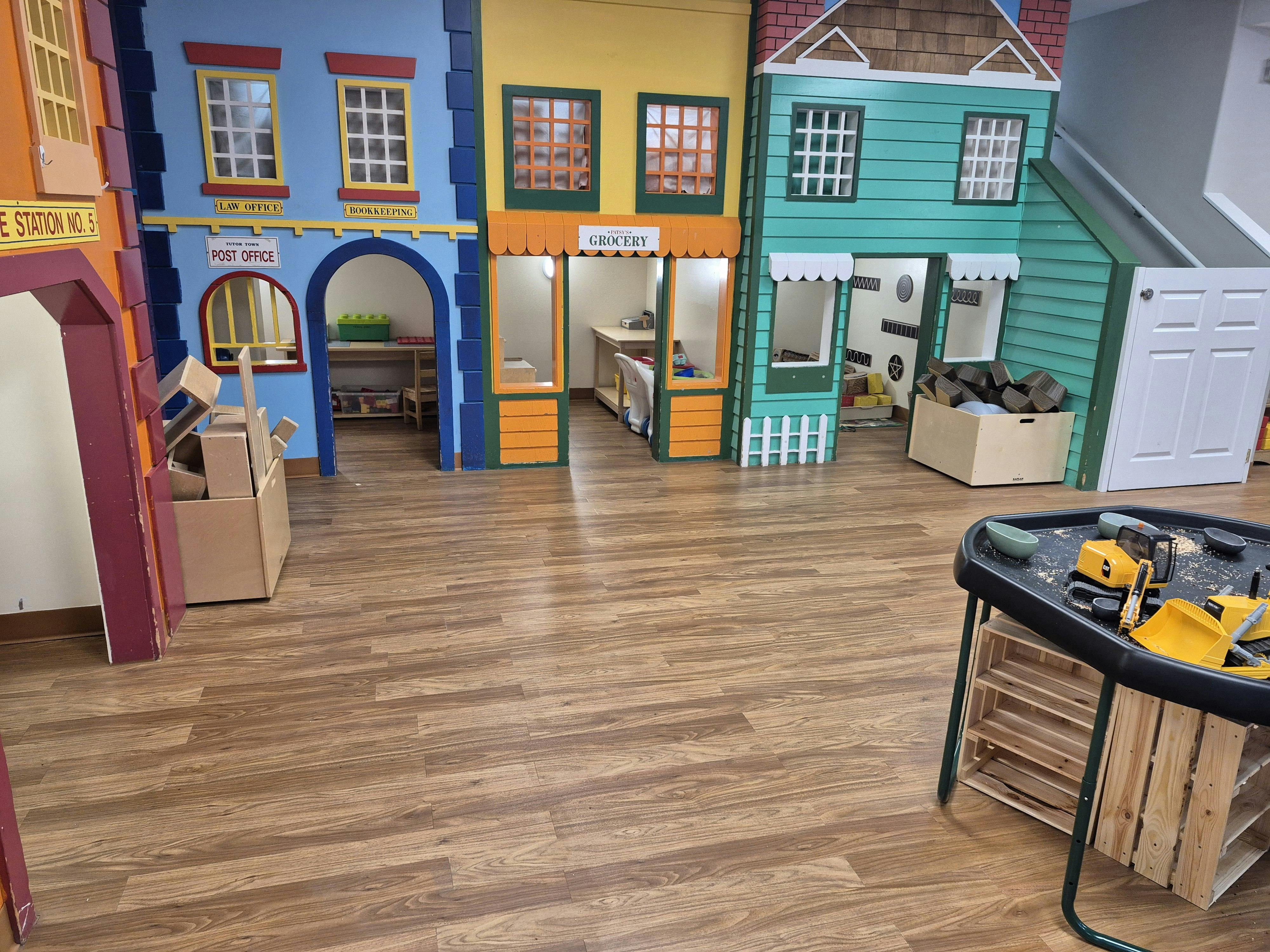 Colorful playhouse facades of a town, including a post office and grocery store