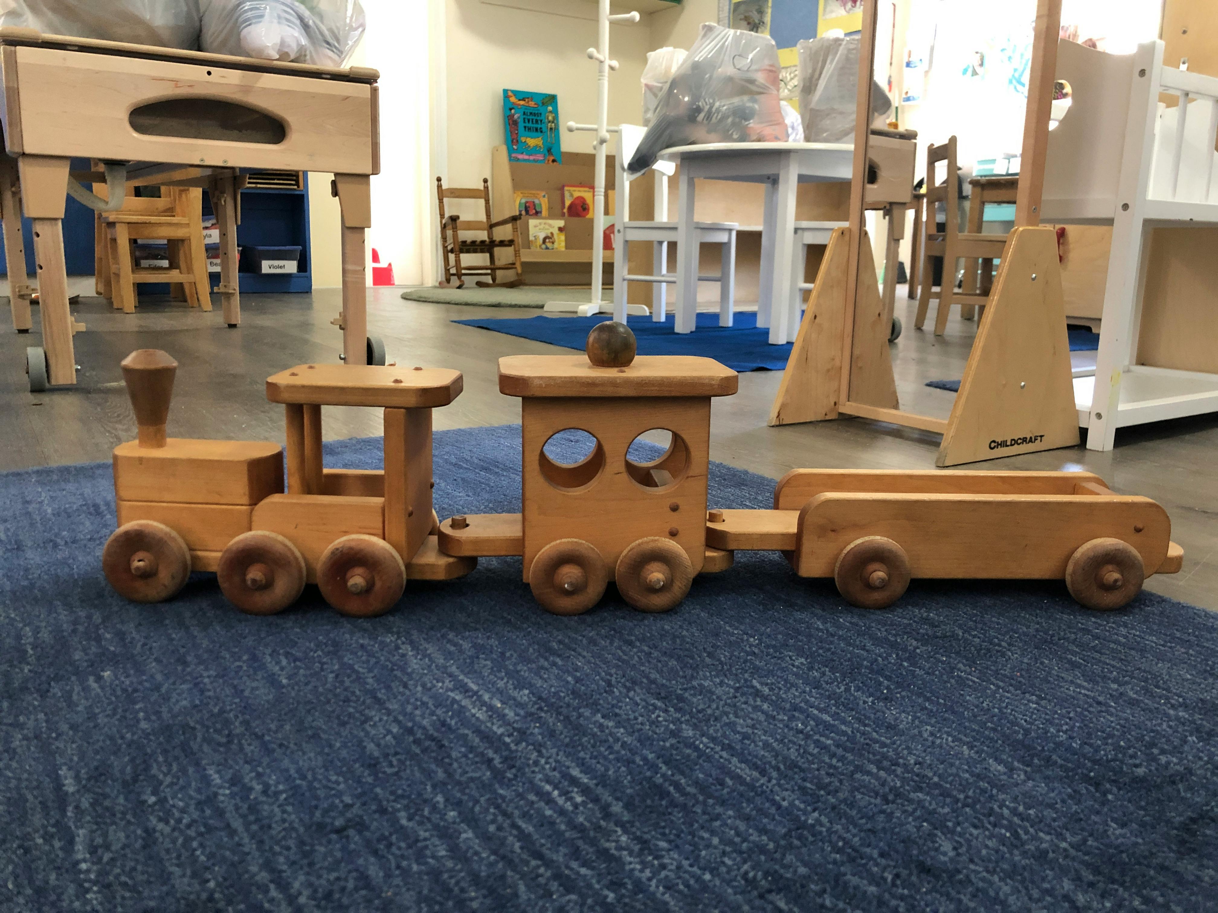 Wooden toy train on a blue rug
