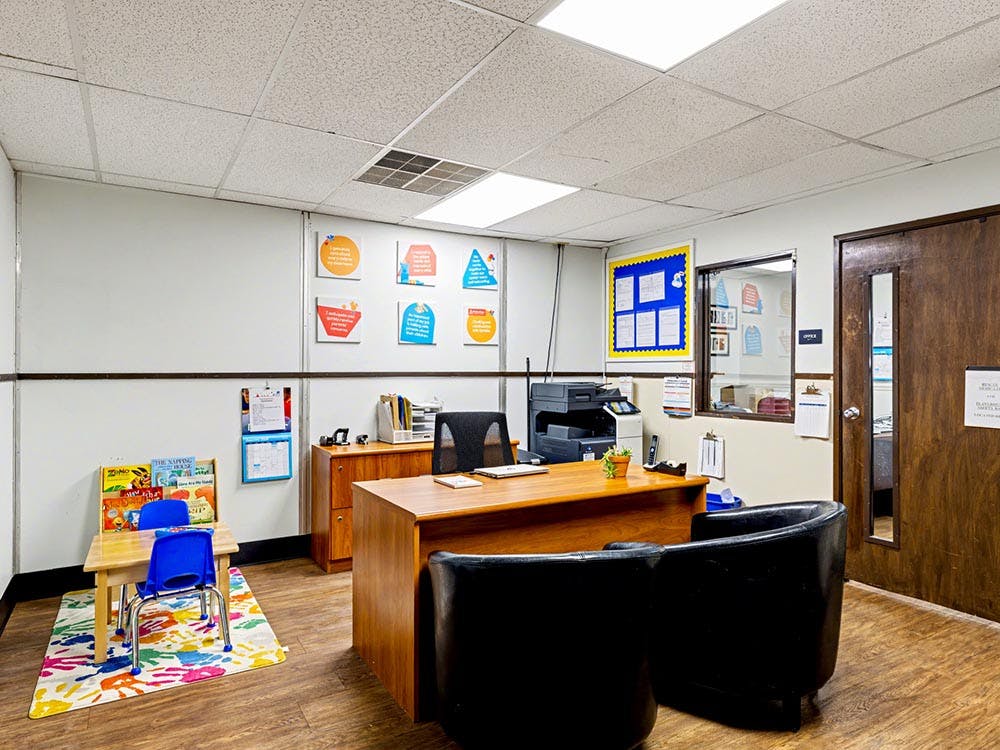 An office with a desk, chairs, and a small table with two child-sized chairs