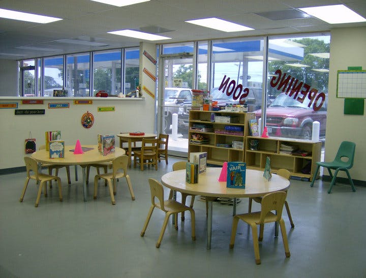 Classroom with small tables and chairs, shelves, and large windows