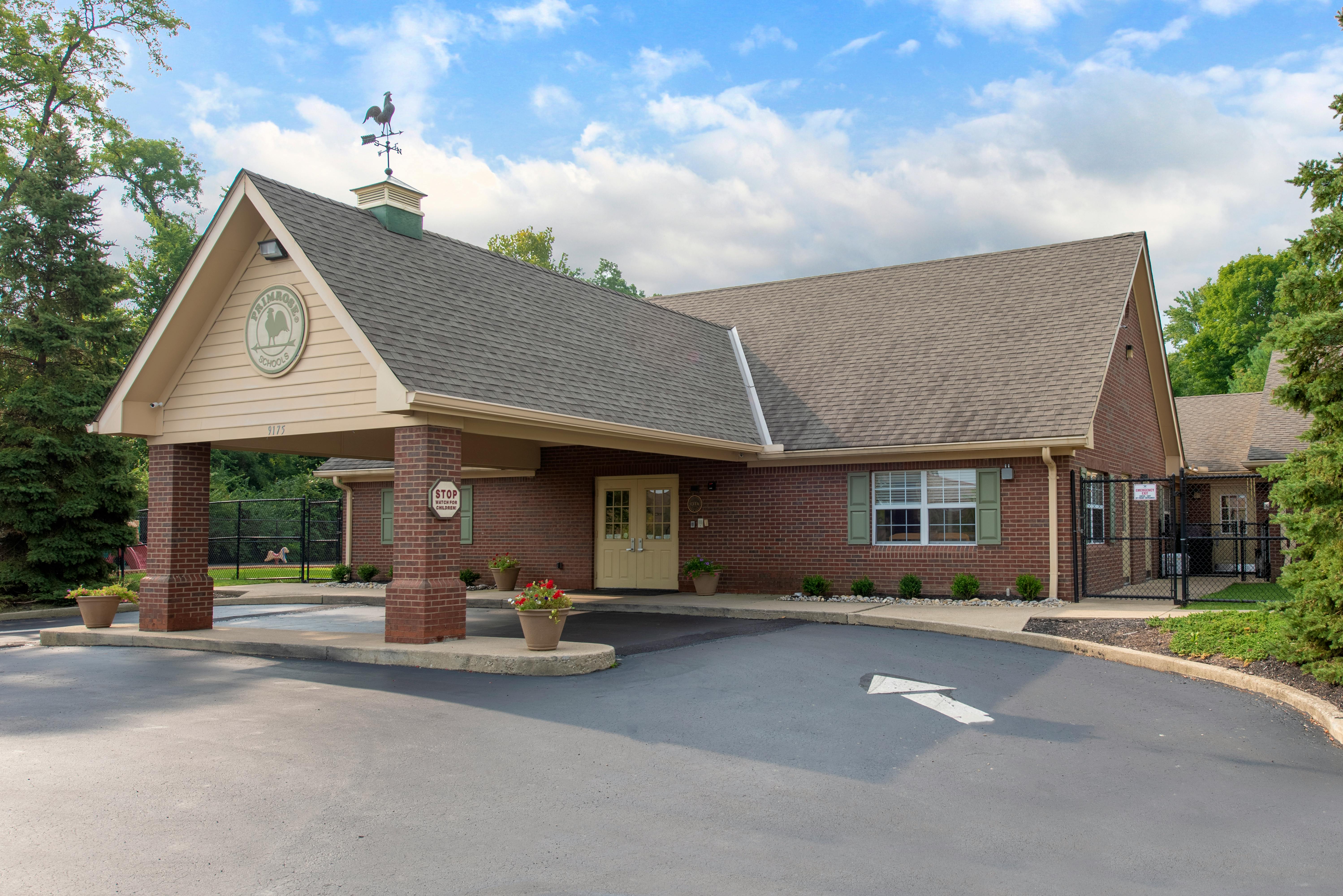 Brick building with a prominent front entrance and covered driveway