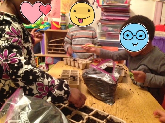 People and children planting seeds in small pots at a table