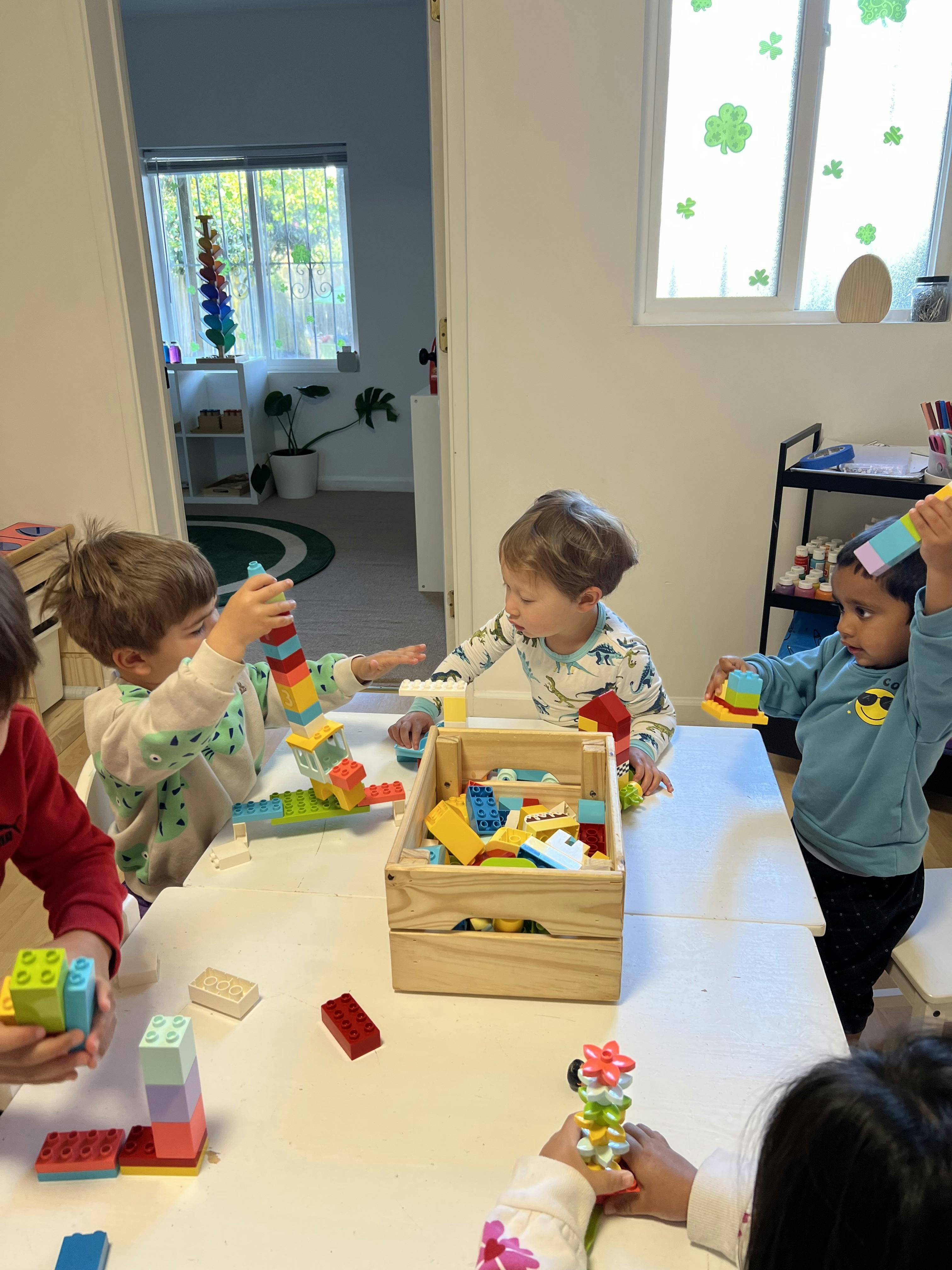 Children playing with colorful building blocks at a table